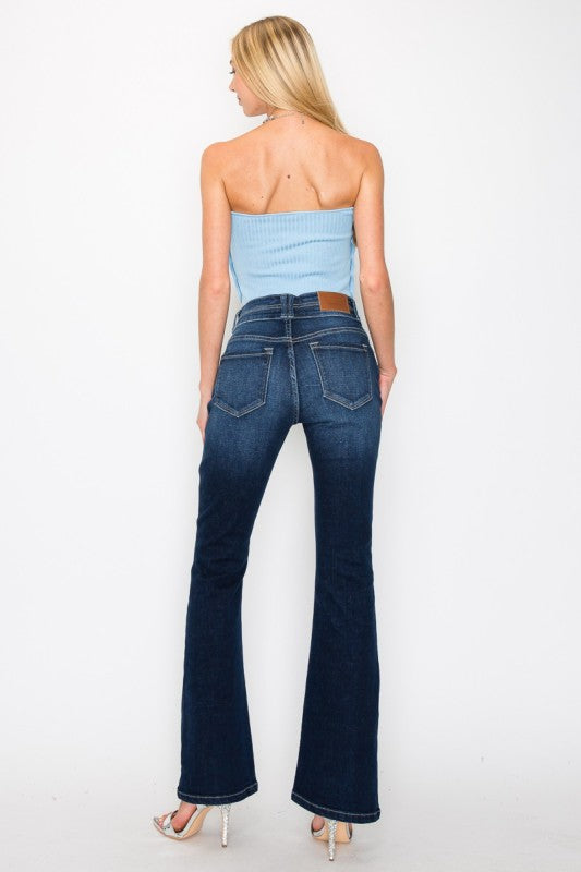 Artemis Vintage back view of model wearing women's tummy control bootcut jeans in dark wash with heels