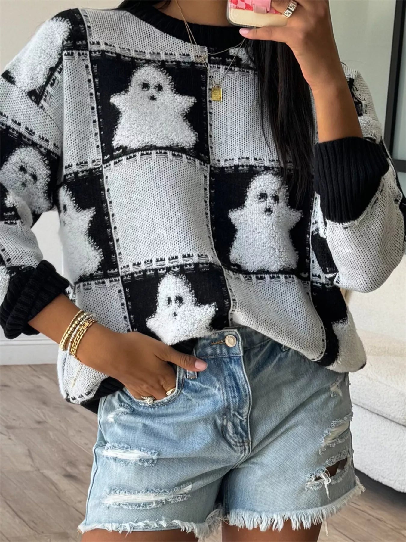 Trendsi Drop Shoulder Sweater in black and white with ghost print, paired with distressed denim shorts