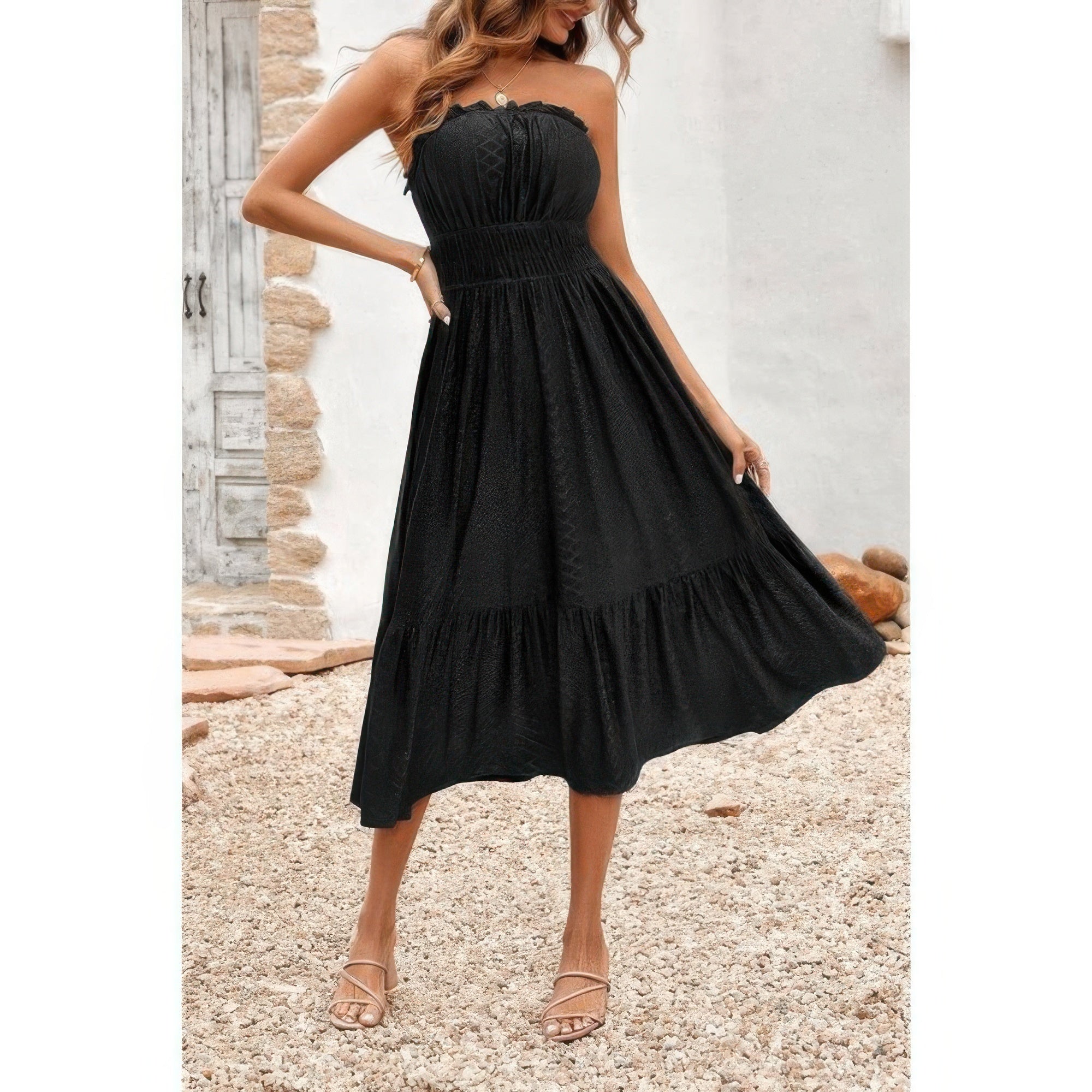 Model wearing black strapless Elasit Waist Ruffle Dress with smocked elastic waist and tiered ruffle hem styled with sandals