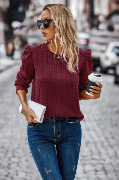 Loose Fit Pullover burgundy cable knit with puff sleeves on woman holding coffee and clutch in city