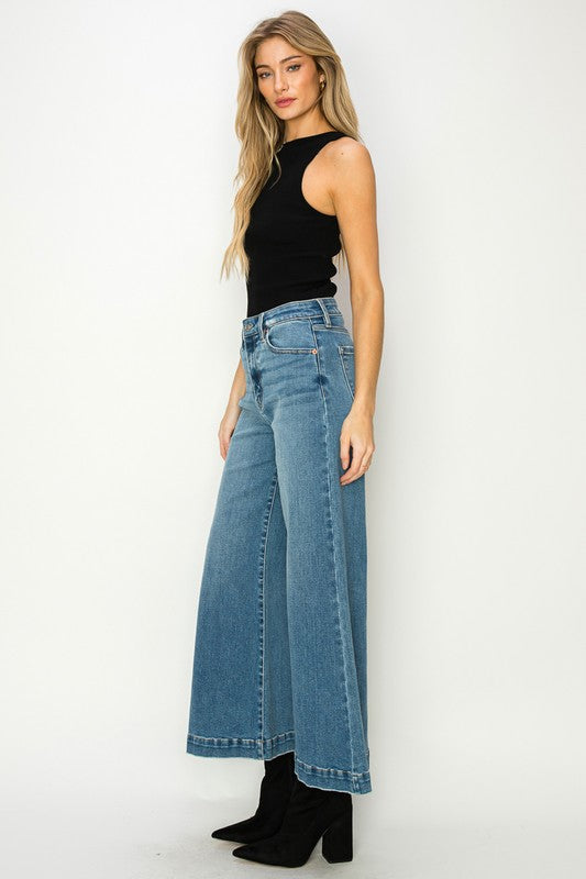 Artemis Vintage high waisted light wash wide leg Stretch Denim Jeans on model with black tank and heeled boots