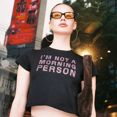 Trendsi black Crop T-Shirt with IM NOT A MORNING PERSON slogan on model wearing sunglasses and hoop earrings