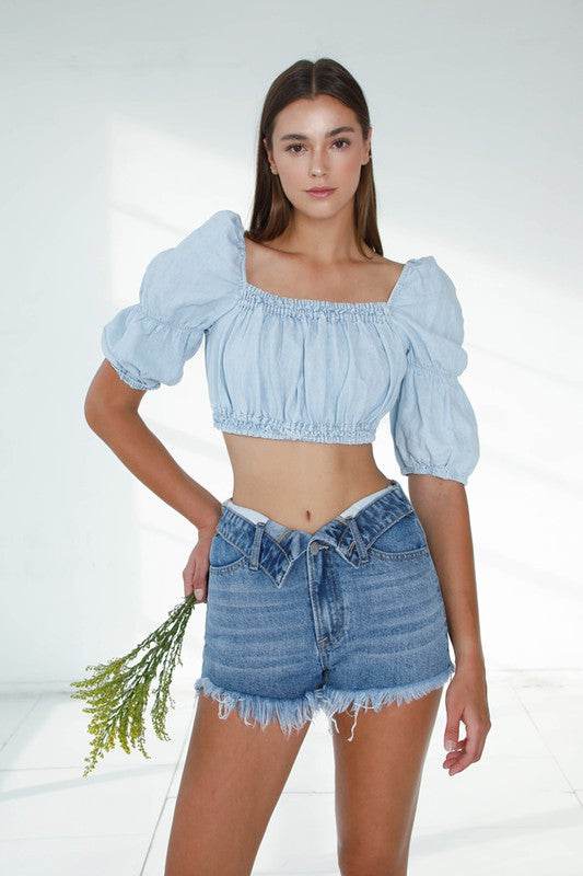 Stylish model wearing Front Ribbon Open Shorts paired with a cropped denim blouse and holding a bouquet
