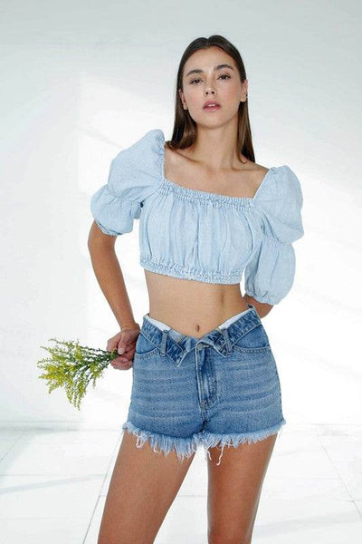 Model wearing Front Ribbon Open Shorts with a trendy crop top and holding a bouquet of flowers