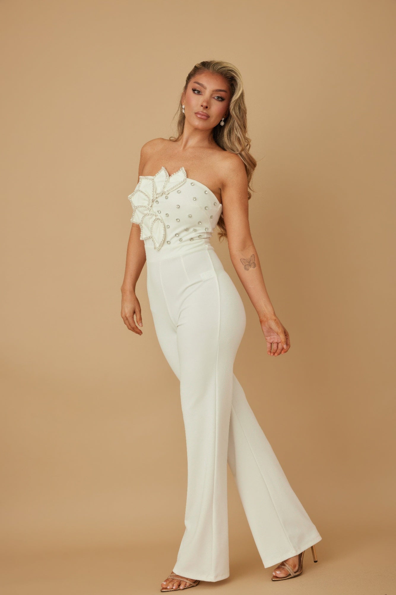 white rhinestone jumpsuit for women strapless embellished bodice with flared pants model wearing heels