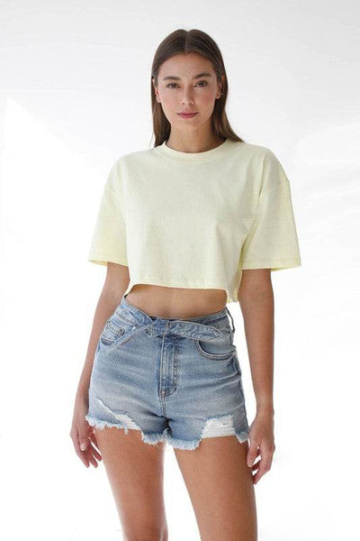 Model wearing High Waisted Denim Shorts with a soft yellow cropped t-shirt for a stylish summer look