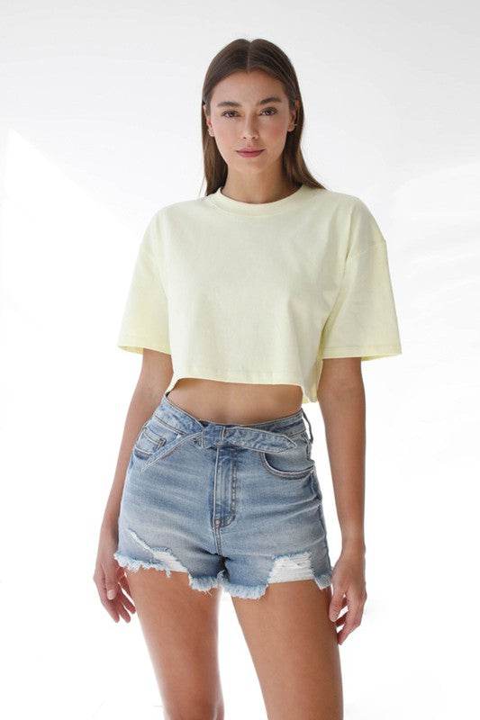 Model wearing High Waisted Denim Shorts with a soft yellow cropped t-shirt for a stylish summer look