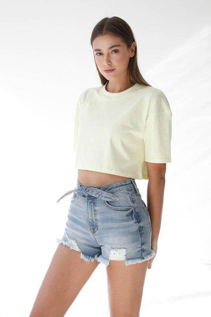 Model wearing High Waisted Denim Shorts paired with a cropped yellow t-shirt for a stylish summer look