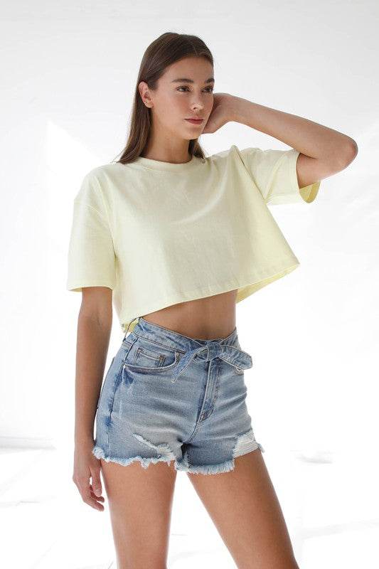 Model wearing High Waisted Denim Shorts paired with a yellow cropped top for a stylish summer look