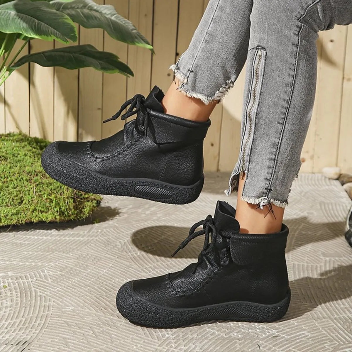 Black lace-up casual ankle boots by Trendsi worn with gray zippered distressed jeans outdoors
