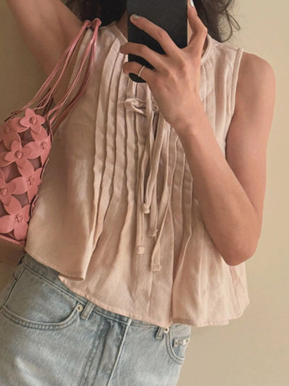 Trendsi Sleeveless Summer Blouse beige pintuck front with tie detail shown worn with light wash jeans and pink bag