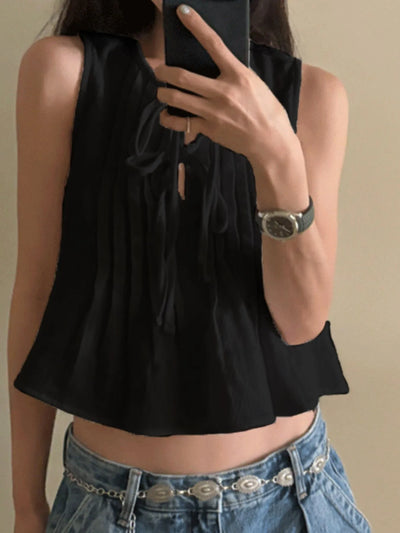 Sleeveless Summer Blouse black pleated cropped top with tie neckline styled with low rise jeans and concho belt