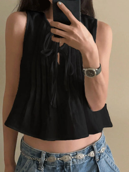 Sleeveless Summer Blouse black pleated cropped top with tie neckline styled with low rise jeans and concho belt