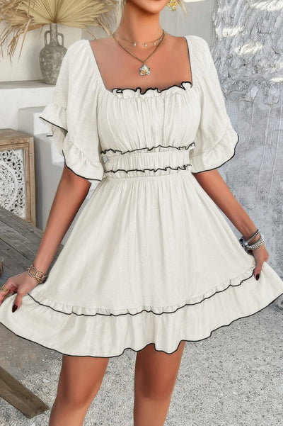 White off shoulder ruffle trim dress with black trim and square neckline and puff sleeves and smocked waist