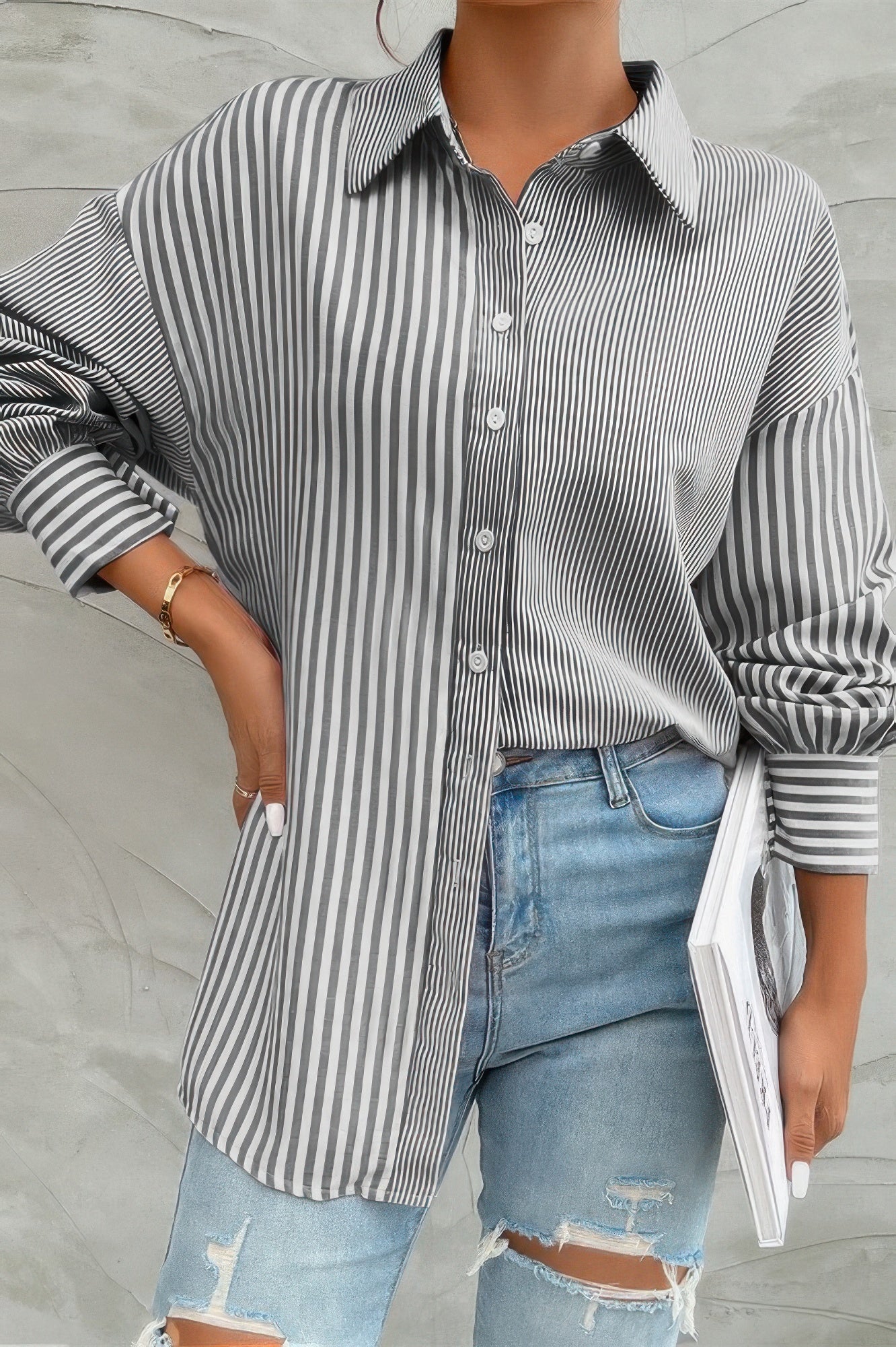 Women wearing gray and white stripe print button down shirt oversized with rolled sleeves and jeans