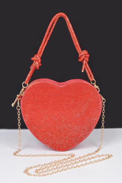 Red glitter Heart Shape Clutch with knotted top handle and detachable gold chain strap on black background