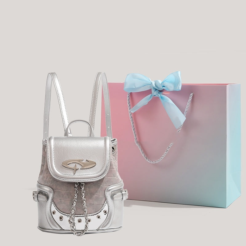 Trendsi Metallic Mini Backpack in silver with chain accents and croc texture beside a pastel gift bag