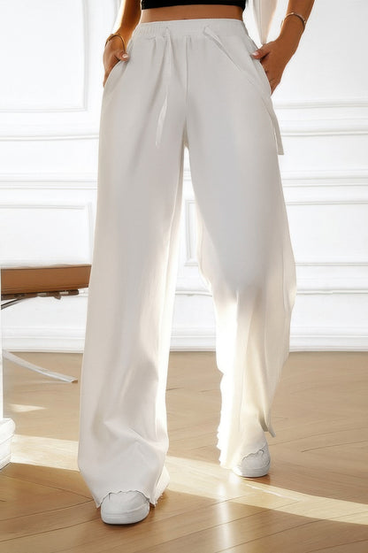 White high rise women's elastic waist straight pants with drawstring and side pockets worn with white sneakers