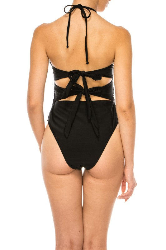 Back view of Mermaid Swimwear Floral Wrap black swimsuit with tie-back design on model