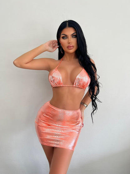 Trendsi model wearing a Metallic Three-Piece Bikini Swimsuit in shiny peach with mini skirt and halter top