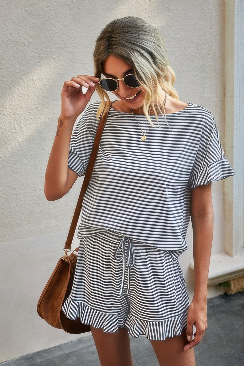 Woman wearing black and white striped short set for women with ruffle sleeves and drawstring ruffle hem shorts and brown bag