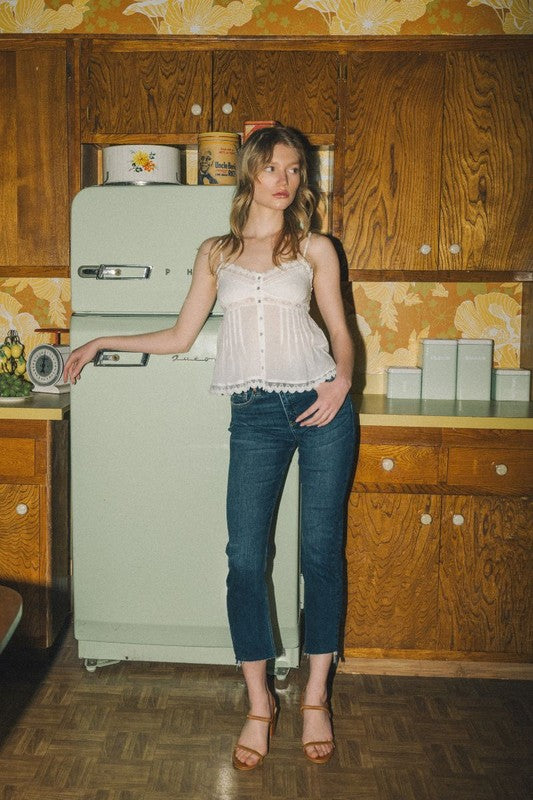 Artemis Vintage model wearing tummy control high rise jeans for women in retro kitchen with white tank top