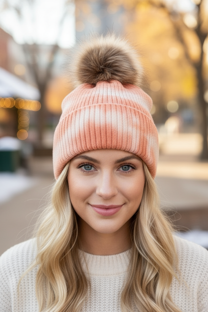 Peach tie-dyed beanie with fur pom-pom at winter market