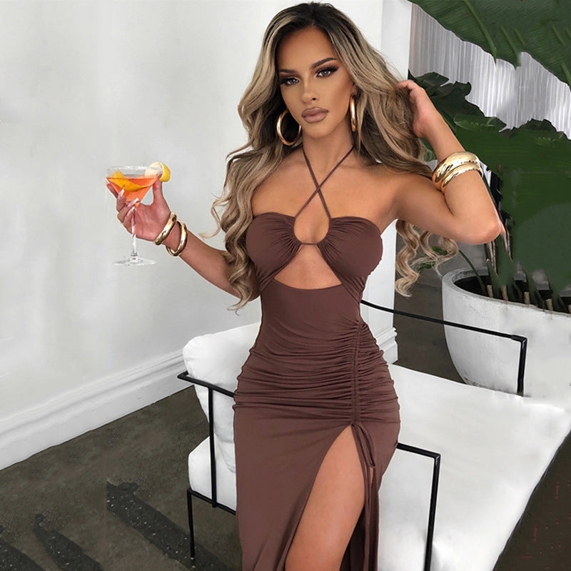 Trendsi Ruched Cutout Cross Halter Maxi Dress in brown worn by model with gold hoop earrings and bracelets