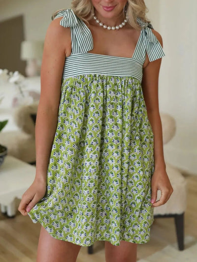 Trendsi Tie Shoulder Mini Dress green floral print with striped bodice and bow straps on model