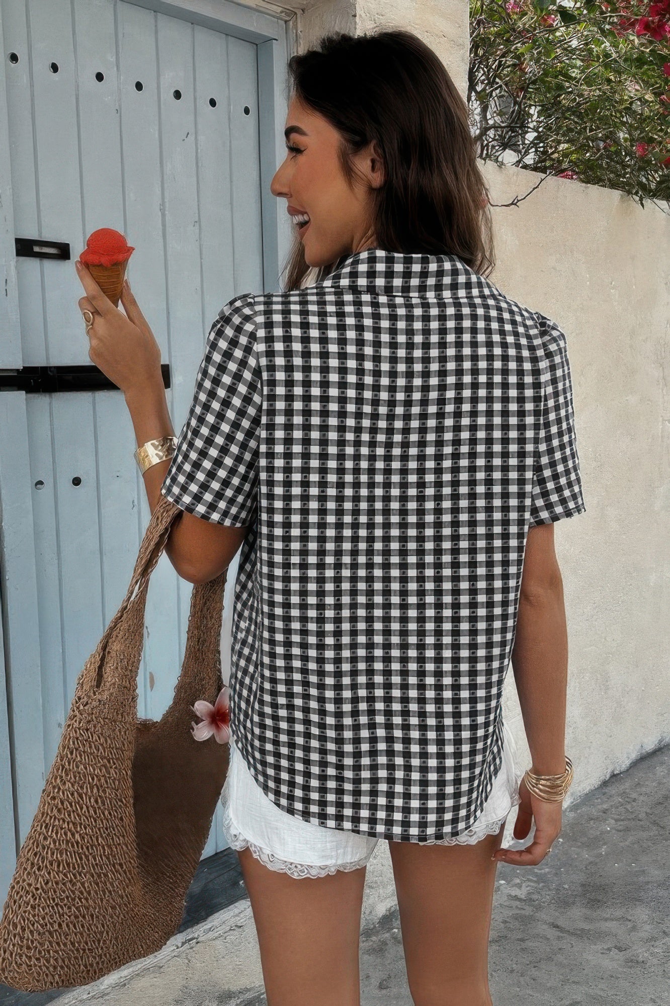 Back view of woman wearing CCWHOLESALECLOTHING women’s plaid button down shirt in black and white gingham short sleeve