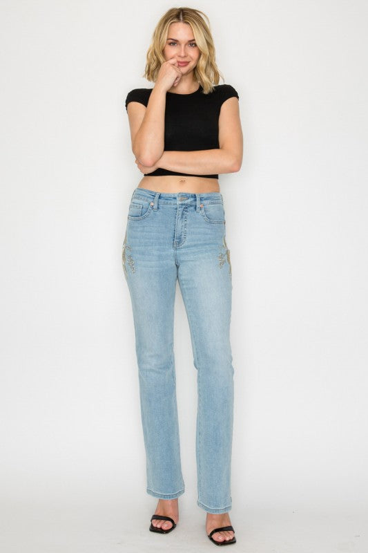 Artemis Vintage model wearing women's high rise embroidered bootcut jeans light wash with floral side embroidery