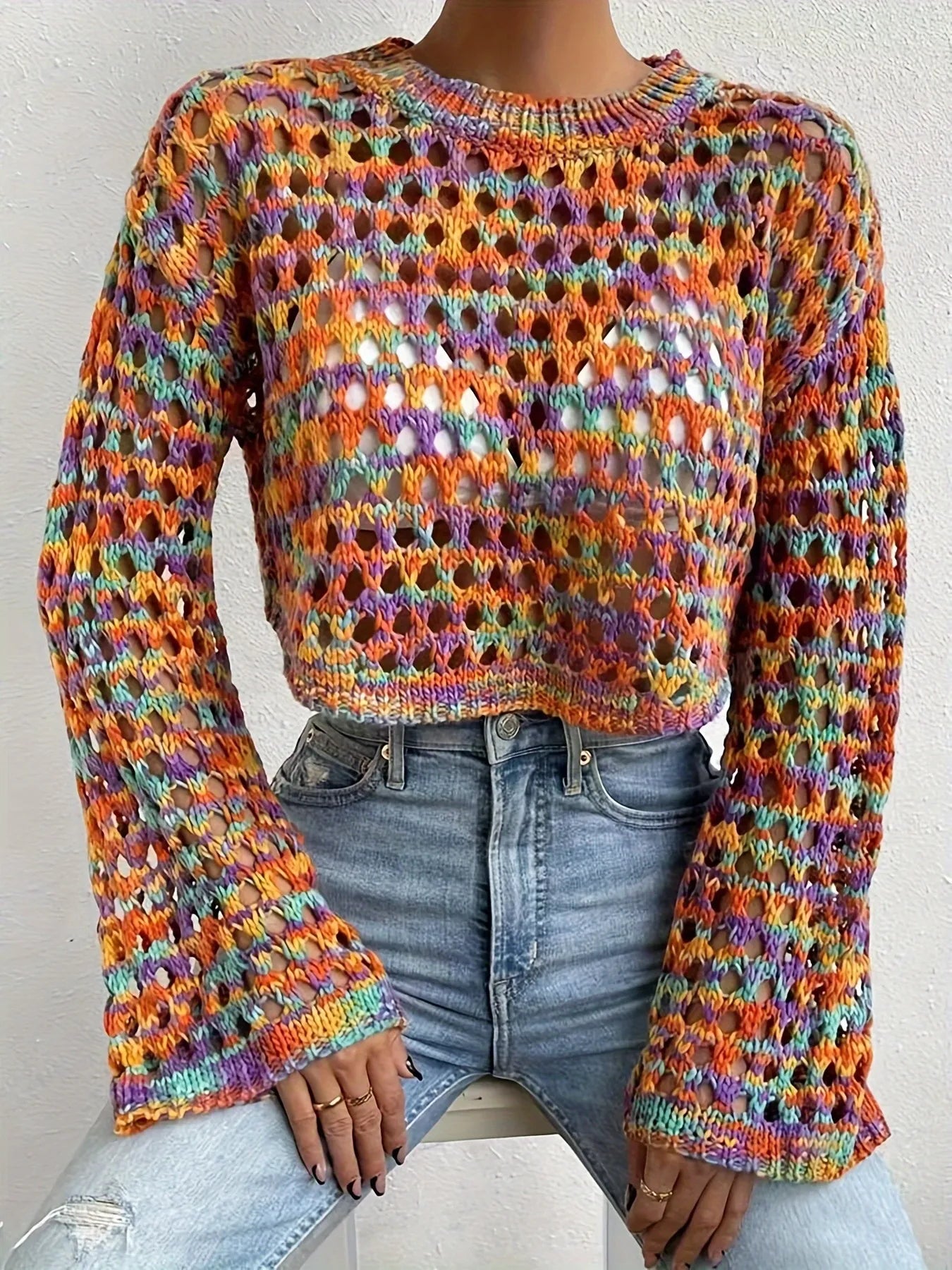 Trendsi Hollow Out Cropped Sweater multicolor open knit with bell sleeves paired with high waisted light blue jeans