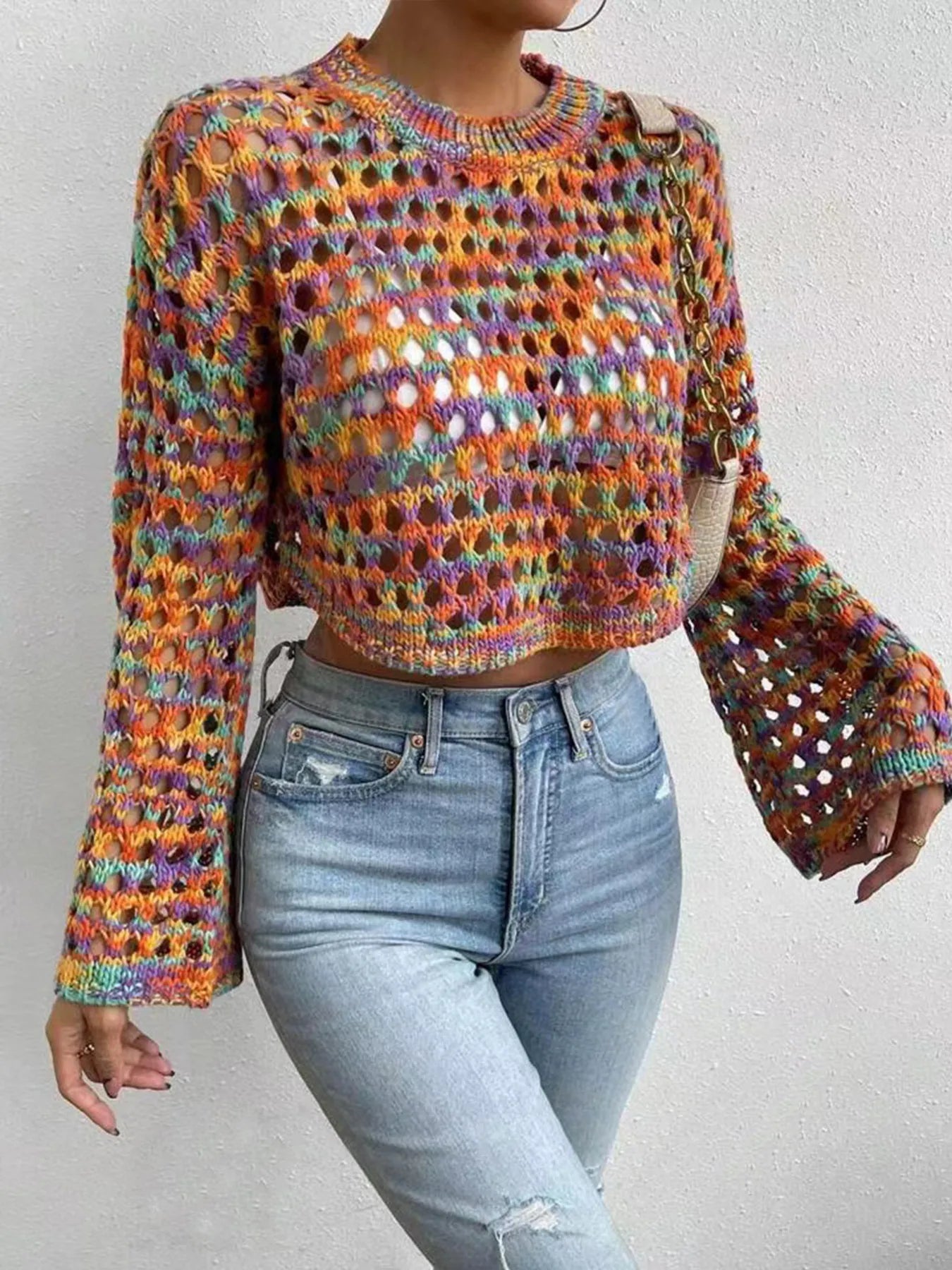 Trendsi Hollow Out Cropped Sweater multicolor open knit with bell sleeves styled with high waisted light wash jeans