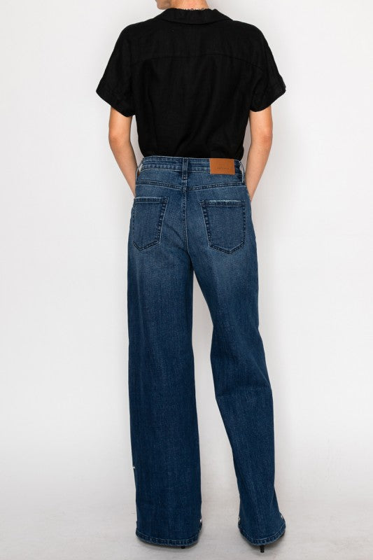Artemis Vintage back view of model in dark wash high rise wide leg jeans for women with tucked black shirt