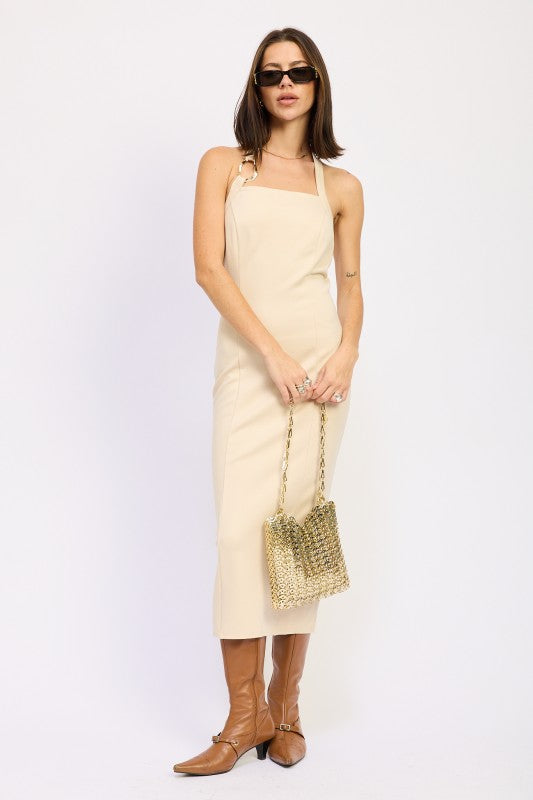 Emory Park beige open back midi dress on model with sunglasses gold chain bag and brown boots