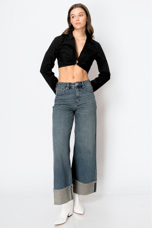 Model wearing Artemis Vintage women's tummy control wide leg jeans with high waist cuffed hem and white boots