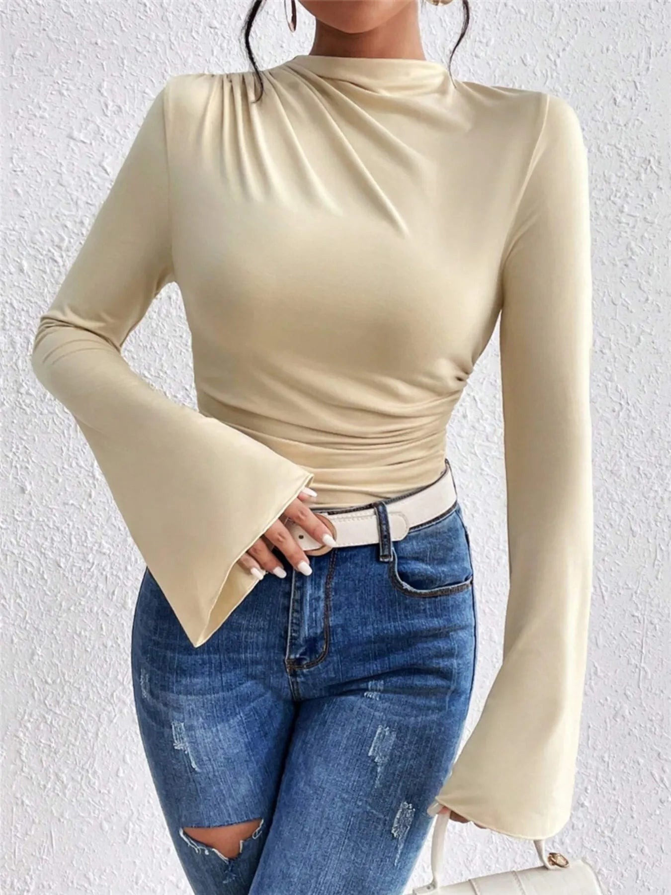Trendsi beige long sleeve Fitted T-Shirt with mock neck bell sleeves and ruched waist styled with ripped blue jeans