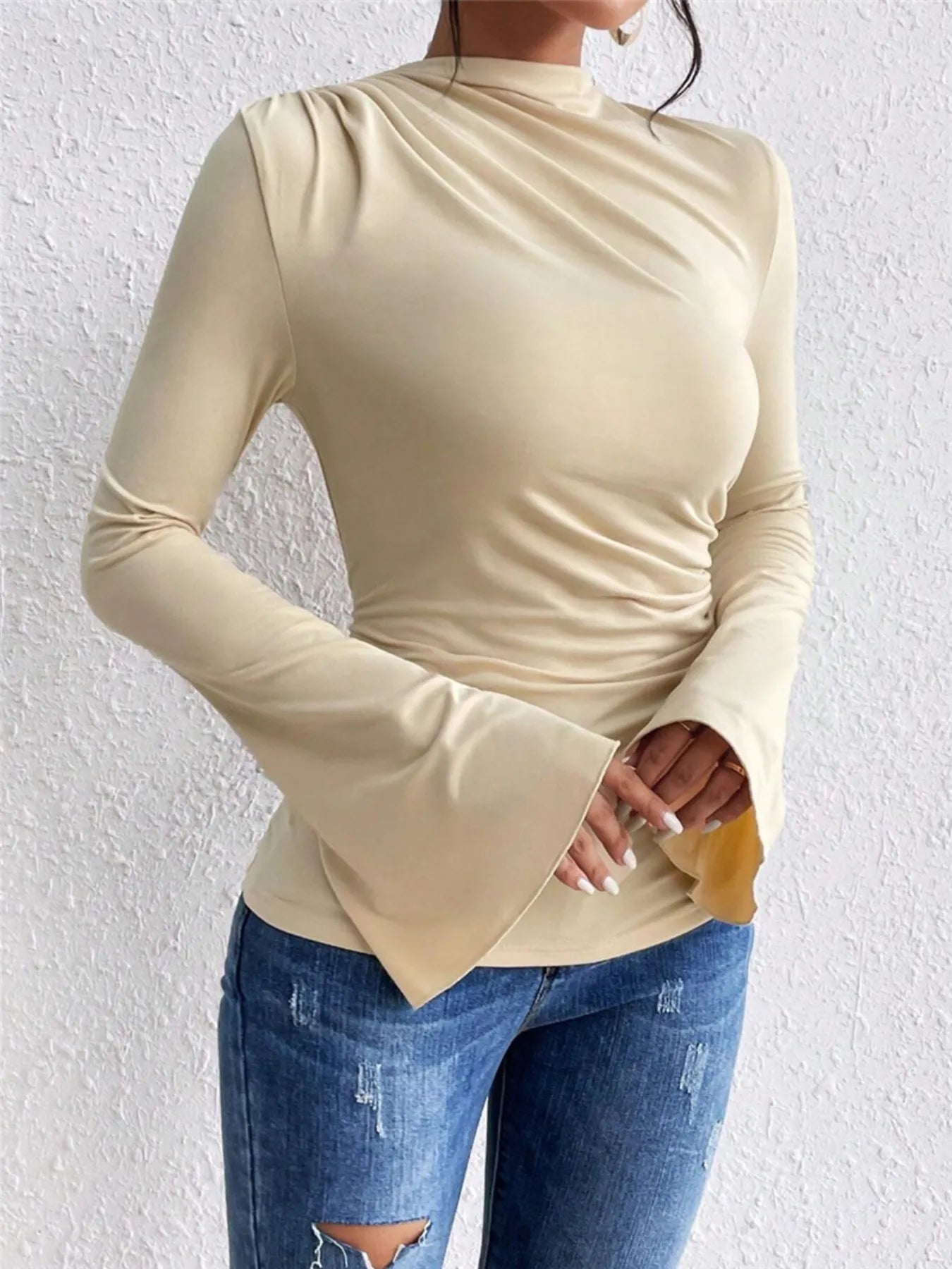 Trendsi cream long sleeve mock neck Fitted T-Shirt with ruched side and bell sleeves paired with distressed jeans
