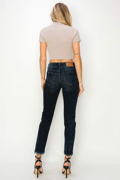 Back view of model wearing Artemis Vintage women's mid rise cigarette jeans in dark wash with cropped beige top and heels