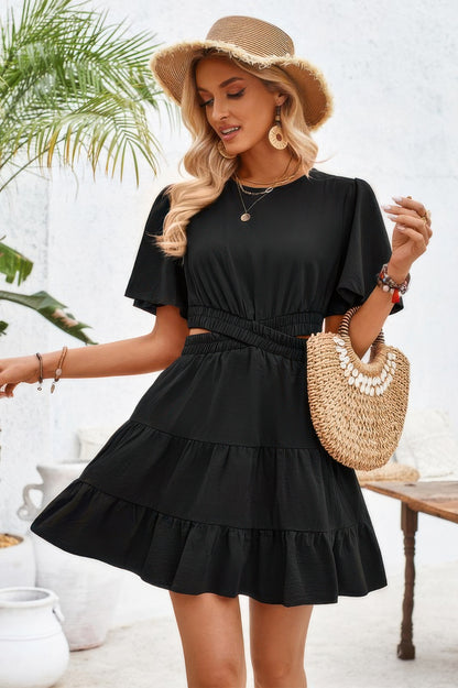 Woman wearing black dress with cross cut out fit elastic waist and short flutter sleeves with straw hat