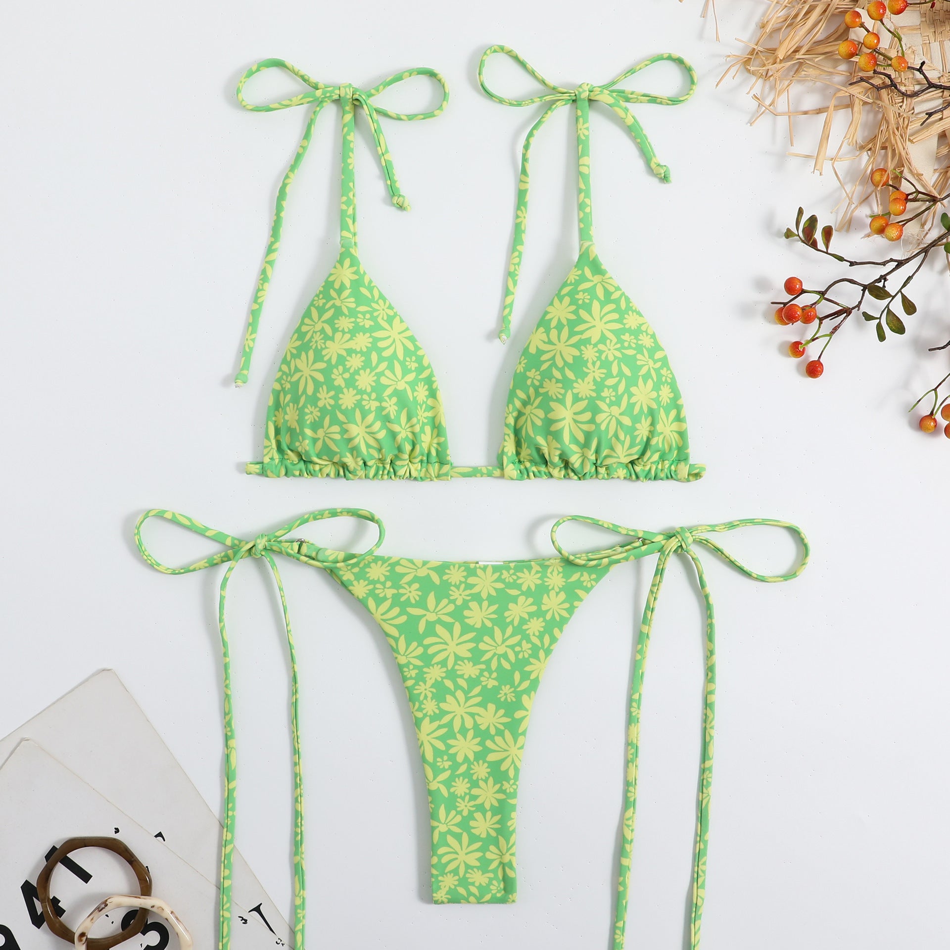 Stylish Floral Self Tie Bikini in green with yellow floral pattern by Trendsi laid flat on white background