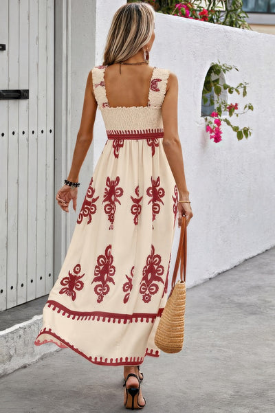 Back view of woman in cream maxi sleeveless square neck dress with red embroidery smocked bodice and straw bag