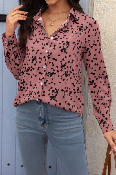 Woman wearing Button Down Loose Blouse pink spotted long sleeve collared top tucked into light wash jeans