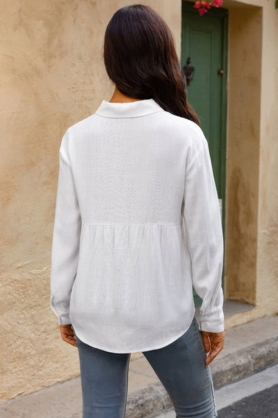 Woman wearing white Button Down Loose Blouse back view with long sleeves paired with gray jeans outdoors