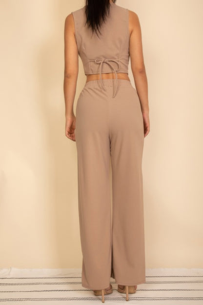 Back view of a woman wearing a tailored button vest in beige with matching wide-leg pants