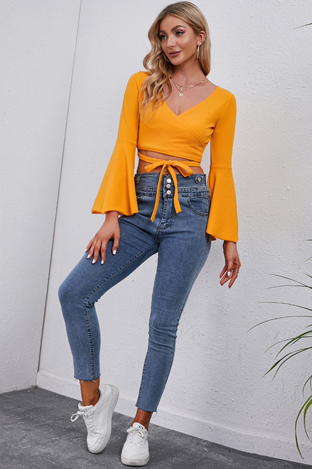 Trendsi Tie Front Cropped Top in vibrant yellow with bell sleeves, styled with high-waisted jeans