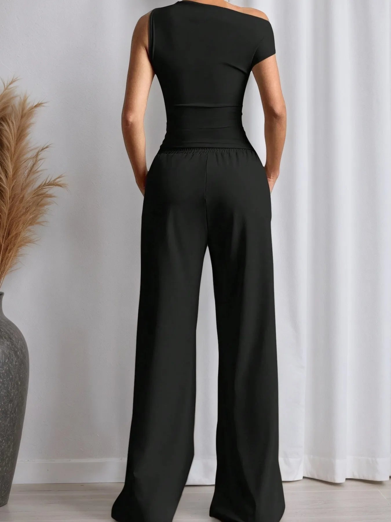 Stylish black top with trendy pants, showcasing a chic and comfortable outfit from Trendsi