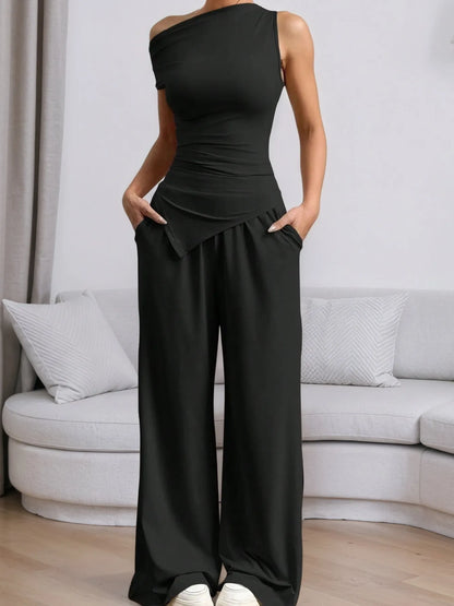 Stylish black top with trendy pants featuring a sleek one-shoulder design and relaxed fit