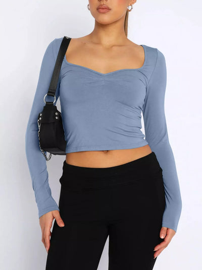 Trendy Fitted Tee in blue with a scoop neckline and long sleeves paired with black pants