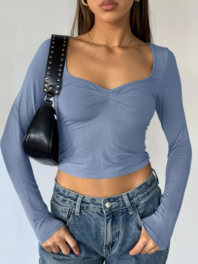 Trendy Fitted Tee in light blue with long sleeves and a scoop neckline, paired with high-waisted jeans